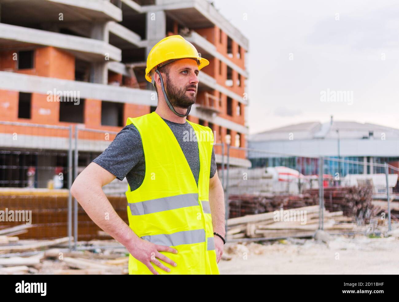 Un ingegnere che posa di fronte alla costruzione di un edificio è funzionamento di Foto Stock