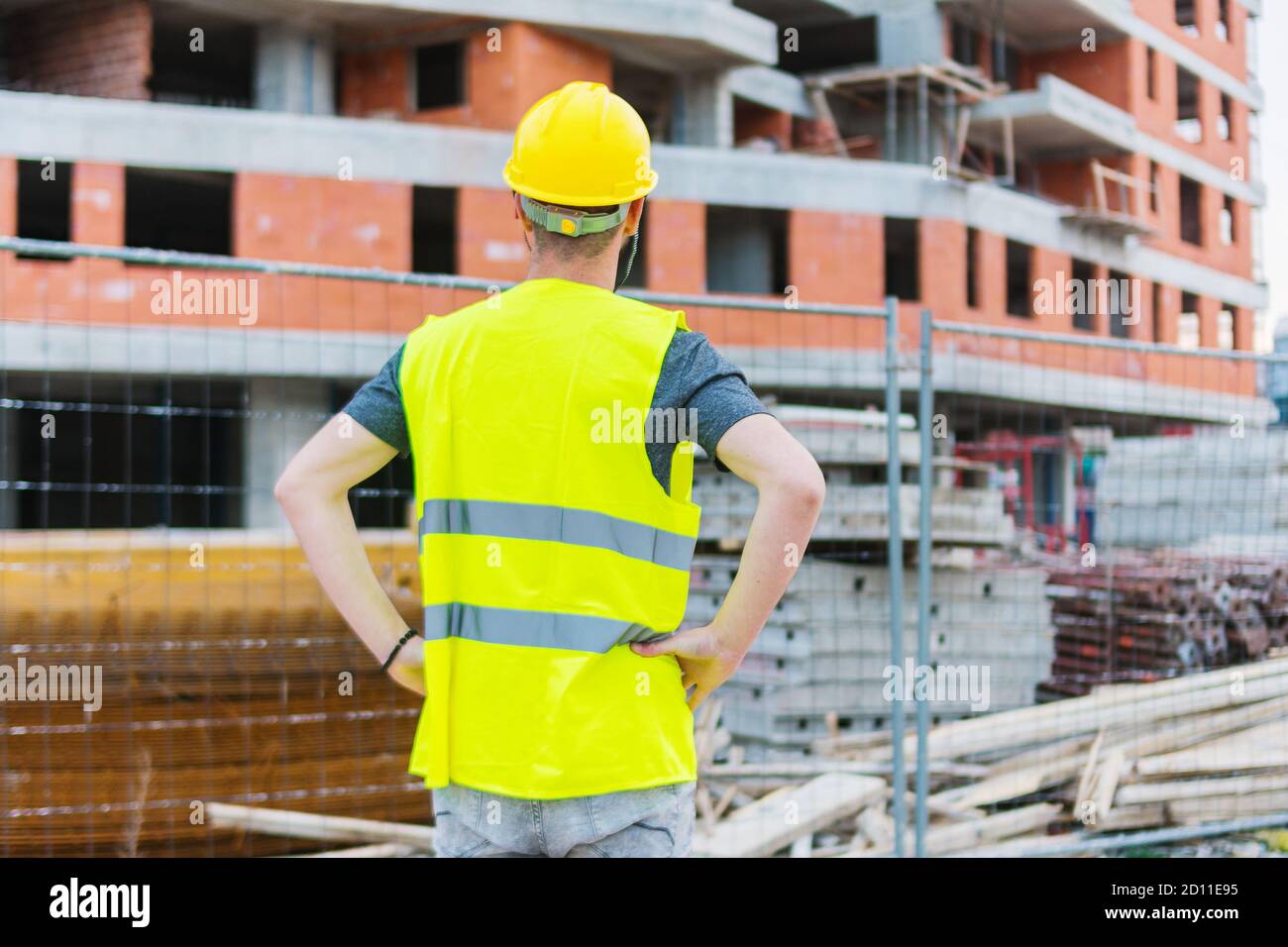 Costruendo il lavoratore di costruzione engeeneer che guarda all'edificio construcion lui sta lavorando su Foto Stock