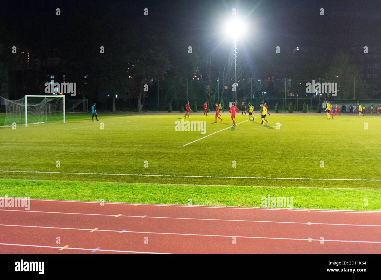 Giocatori che giocano una partita di calcio di notte Foto Stock