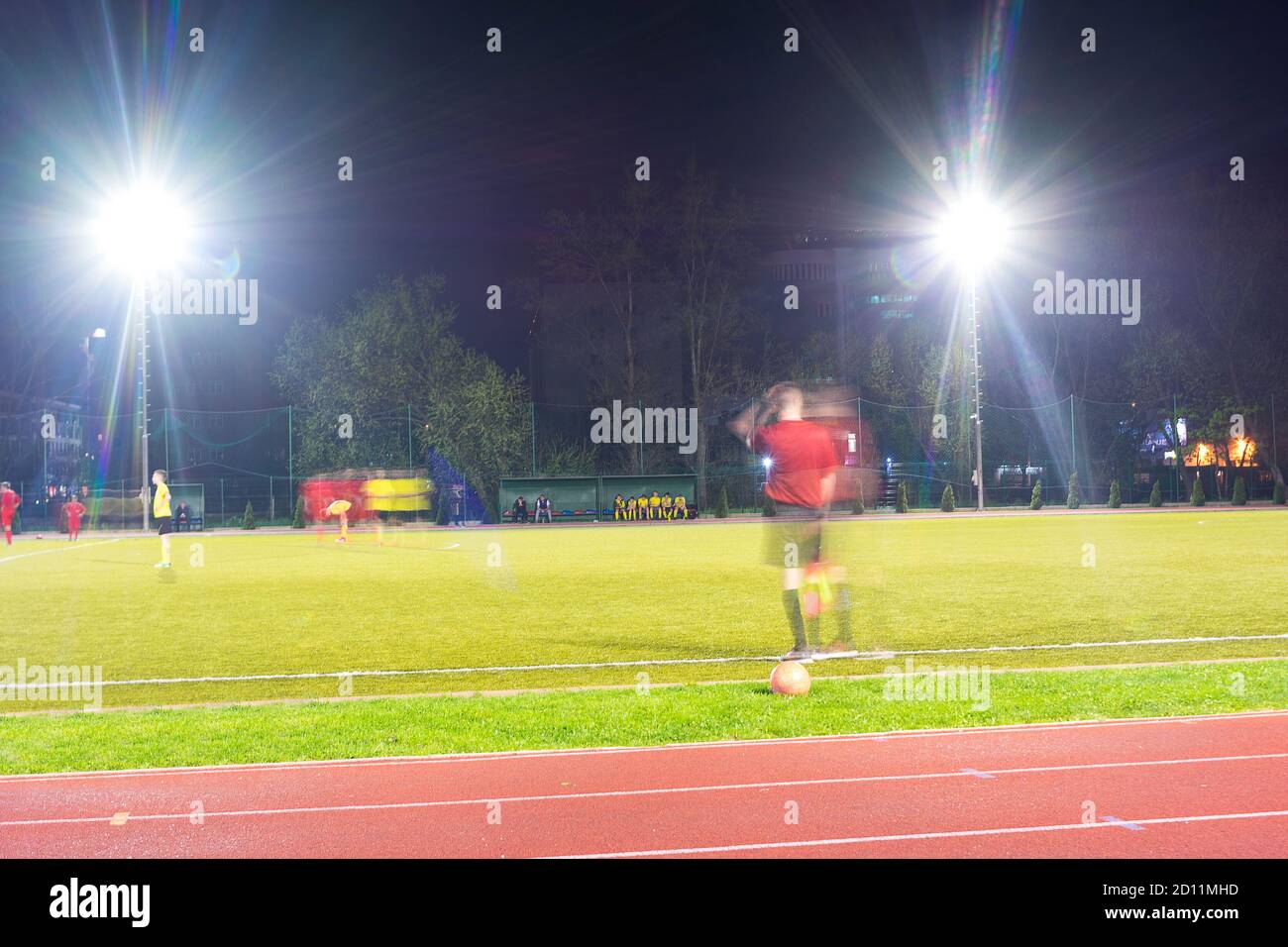 Giocatori che giocano una partita di calcio di notte Foto Stock