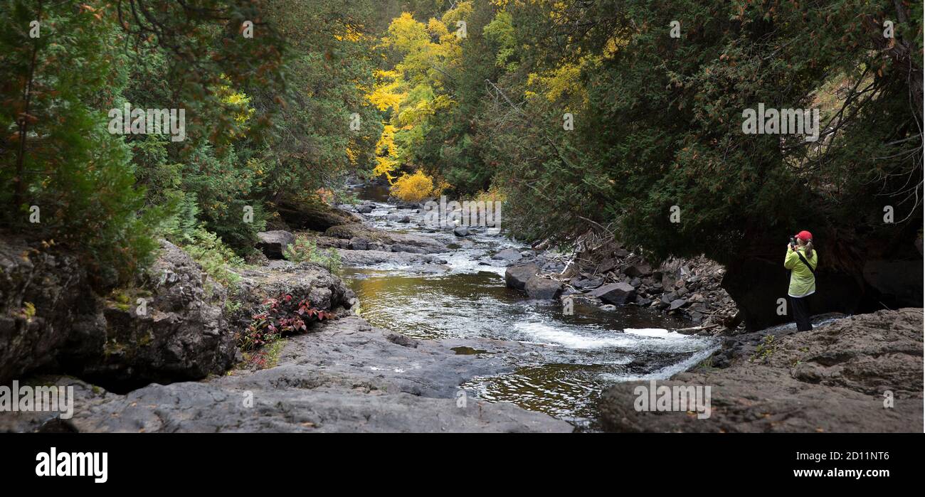 Panorama autunnale scena di un turista che fotografa il fiume Cascade lungo la North Shore del Lago superiore, Minnesota Foto Stock