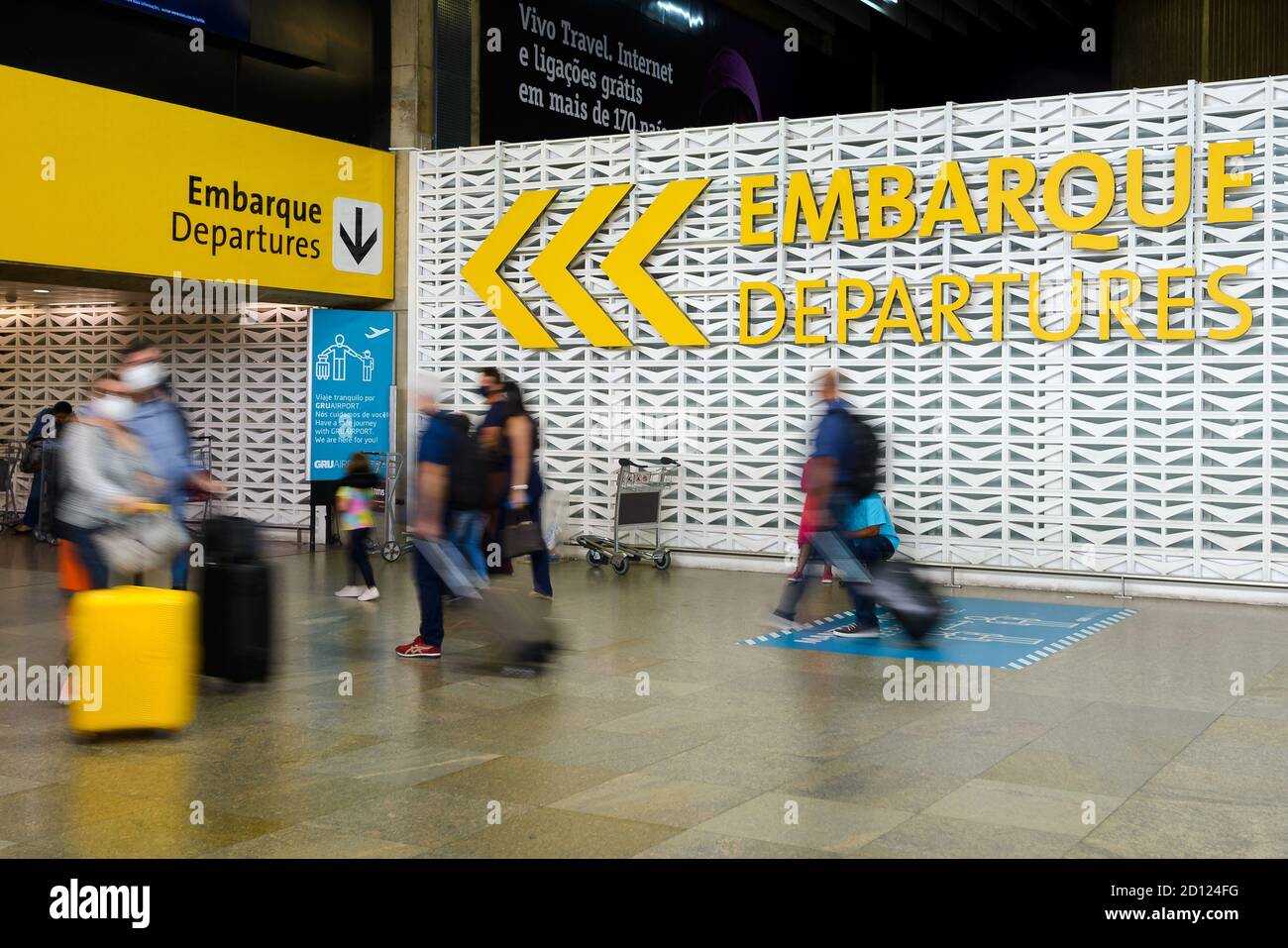 Cartello partenze aeroporto Guarulhos al Terminal Nazionale 2. Passeggeri poco nitidi di fronte al segnale di partenza all'aeroporto GRU di San Paolo, Brasile. Foto Stock