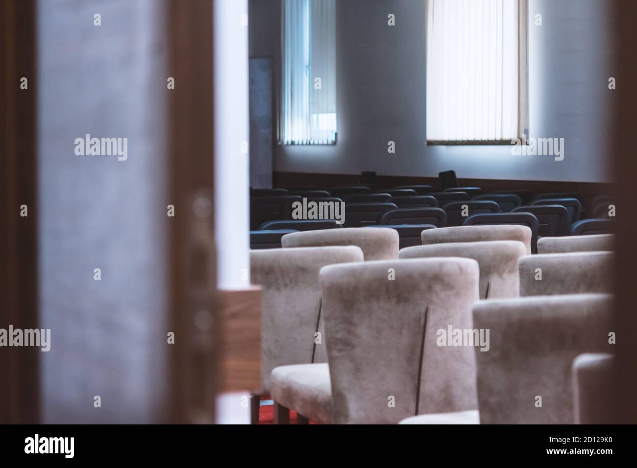 File di sedie marroni e nere disposte nella sala conferenze principale. Foto Stock