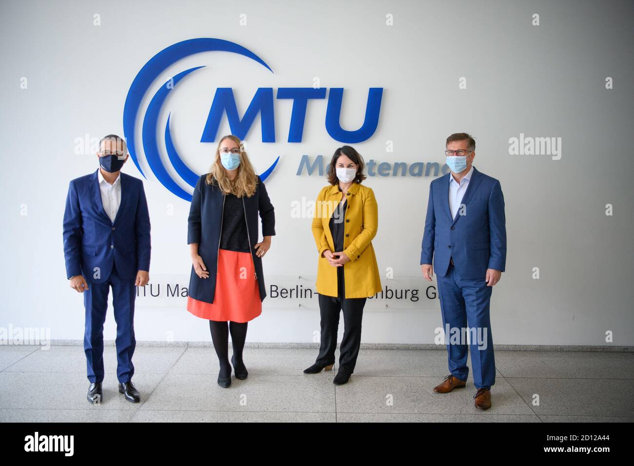 02 ottobre 2020, Brandeburgo, Ludwigsfelde: Andre Sinanian (l-r), presidente e amministratore delegato della MTU Maintenance Berlin Brandenburg, Katharina Dröge, portavoce della politica economica per i Verdi, Annalena Baerbock, presidente nazionale di Bündnis 90/Die Grünen, e Peter Heydenbluth, presidente della Camera dell'industria e del Commercio di Potsdam, si affiancano prima dell'inizio di un tour. MTU Berlin Brandenburg è un'azienda specializzata nella manutenzione di turbine industriali a gas e motori aerodinamici. Foto: Soeren Stache/dpa-Zentralbild/ZB Foto Stock
