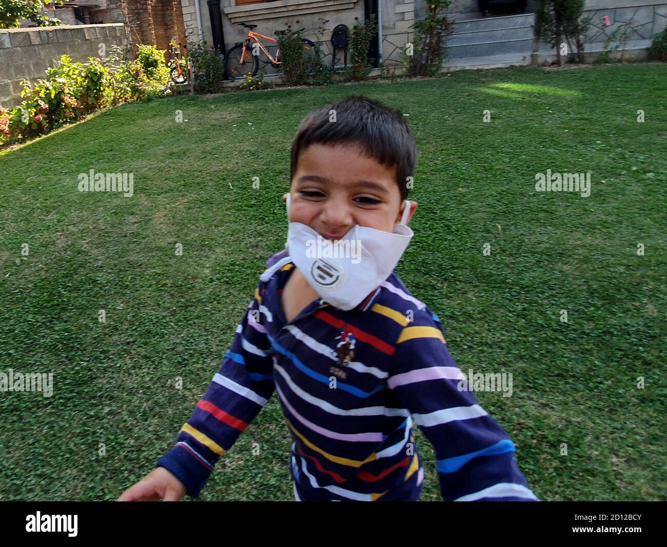 I bambini giocano indossando la maschera dopo il blocco del coronavirus nei paesi asiatici. Foto Stock