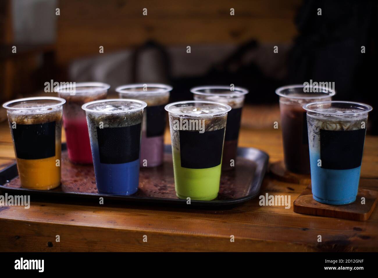 variante di bevande fredde con sapore di frutta. menu di caffè fresco con sfondo scuro. mockup di ghiaccio colorato con tazze di plastica. uva, cioccolato, fragola, Foto Stock