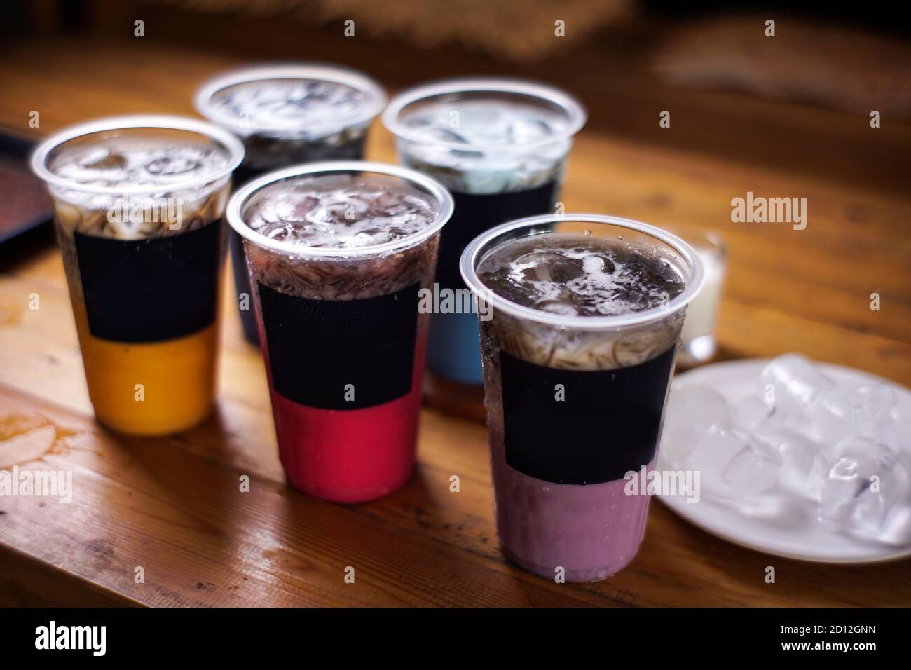variante di bevande fredde con sapore di frutta. menu di caffè fresco con sfondo scuro. mockup di ghiaccio colorato con tazze di plastica. uva, cioccolato, fragola, Foto Stock