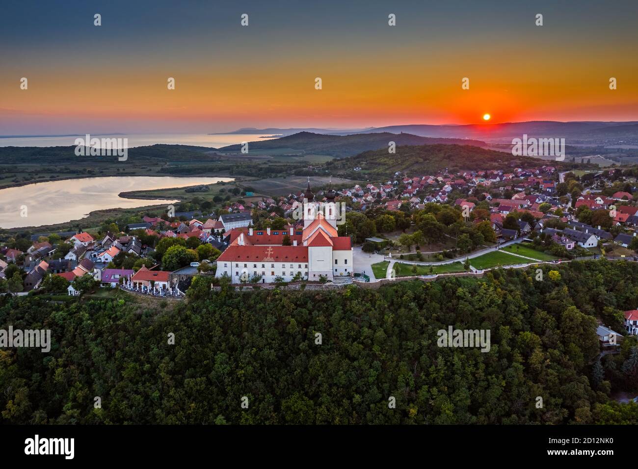 Tihany, Ungheria - veduta panoramica aerea del famoso Monastero Benedettino di Tihany (Abbazia di Tihany, Tihanyi Apatsag) con un bel cielo dorato al sole Foto Stock