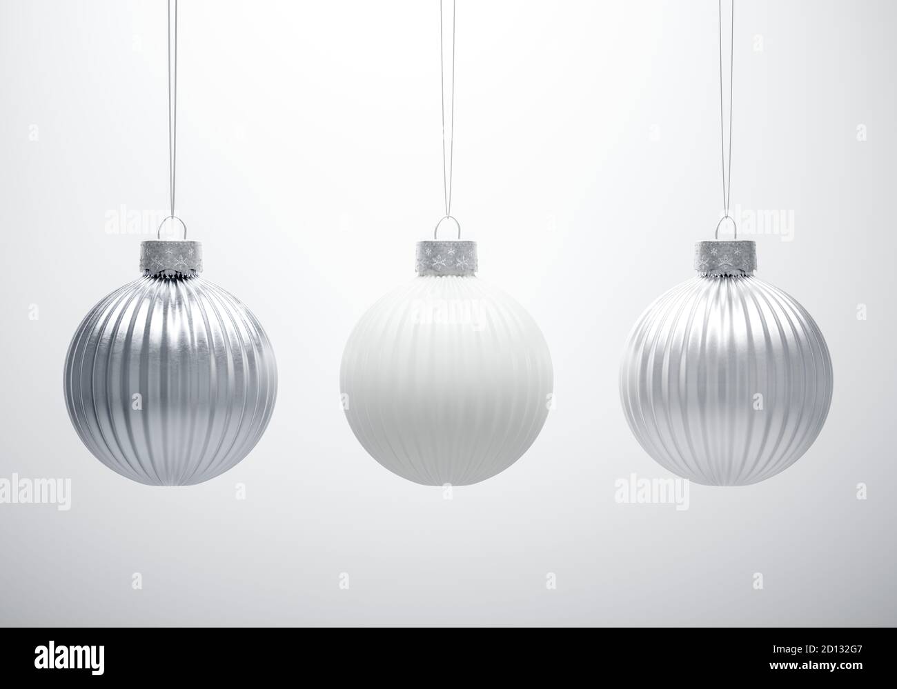 Bianco e nero. Tre palle di Natale appese a strisce verticali su sfondo bianco. Baule testurizzate in metallo bianco e argento. Decorazione di Natale Foto Stock