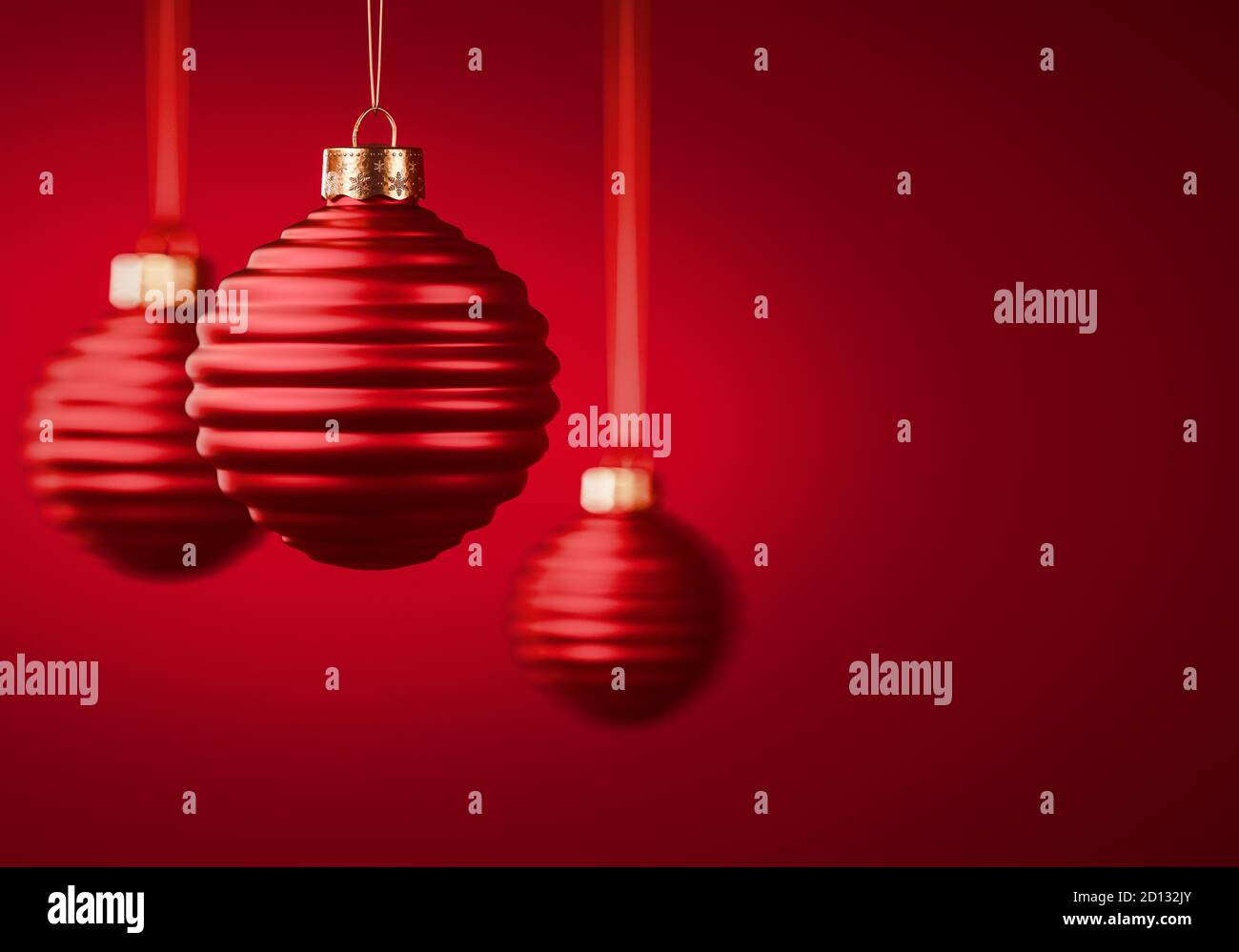 Gruppo di tre palline di Natale a strisce rosse. Baubles appesi su corde contro sfondo rosso borgogna. Decorazione di Natale, atmos festa Foto Stock