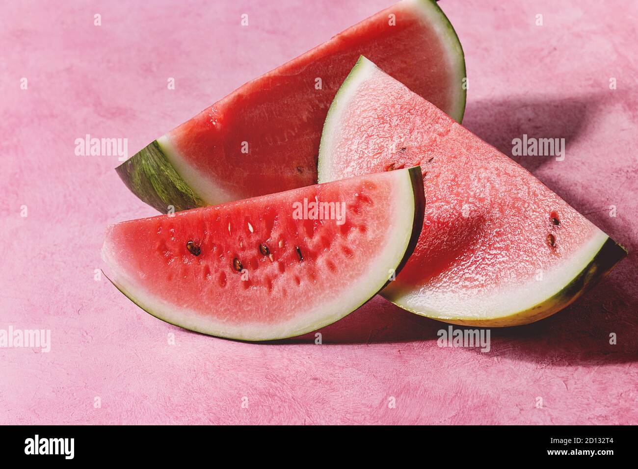 Mature fette di anguria su rosa sfondo texture. Foto Stock