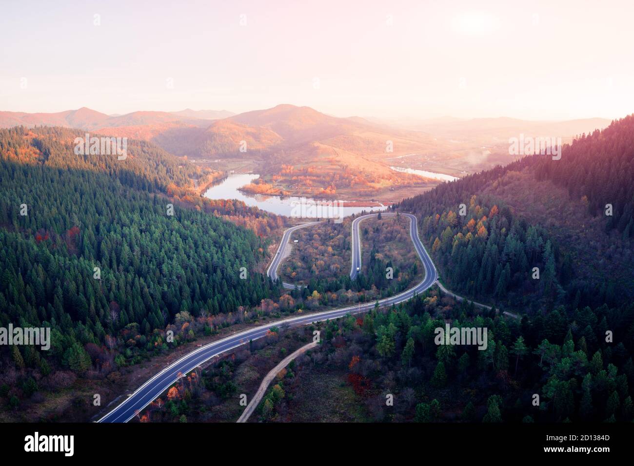 Antenna fuco vista sulle montagne di autunno con la strada di montagna serpentina, fiume e foresta. Fotografia di paesaggi Foto Stock
