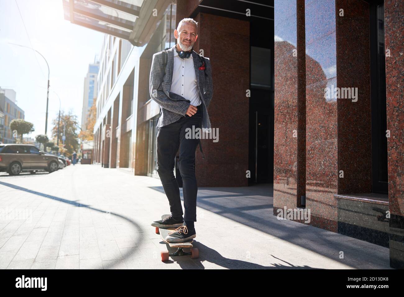 Gioioso anziano che è felice sulla sua longboard Foto Stock