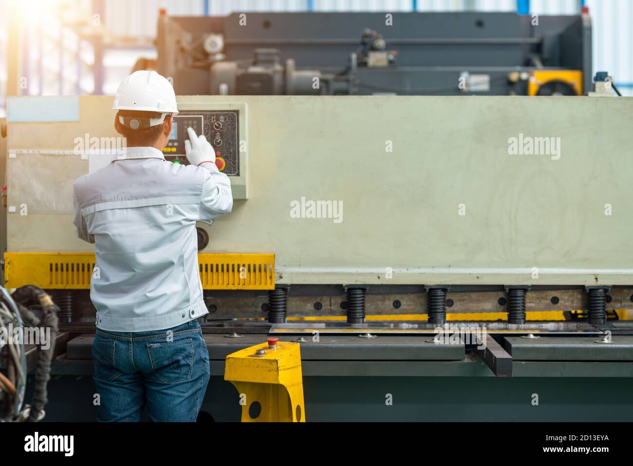 Il lavoratore aziona la macchina piegatrice con freno a pressa idraulica nella fabbrica di costruzioni Foto Stock