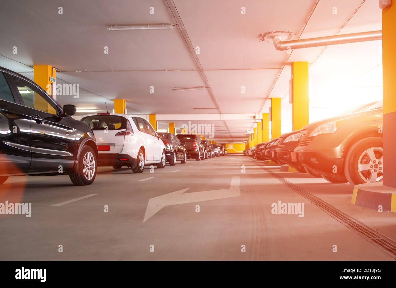 Parcheggio auto custodito su più livelli nel centro commerciale, tramonto. Spazio di copia per testo, tecnologia Foto Stock