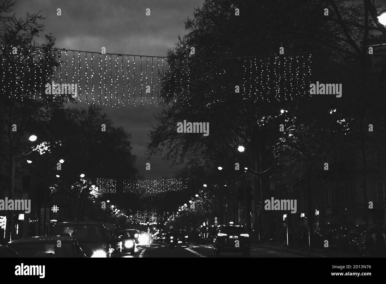 PARIGI, FRANCIA - 7 DICEMBRE 2019: Luci di Natale a Parigi. Boulevard Beaumarchais decorato con illuminazione festosa. Traffico stradale. Bianco nero pho Foto Stock