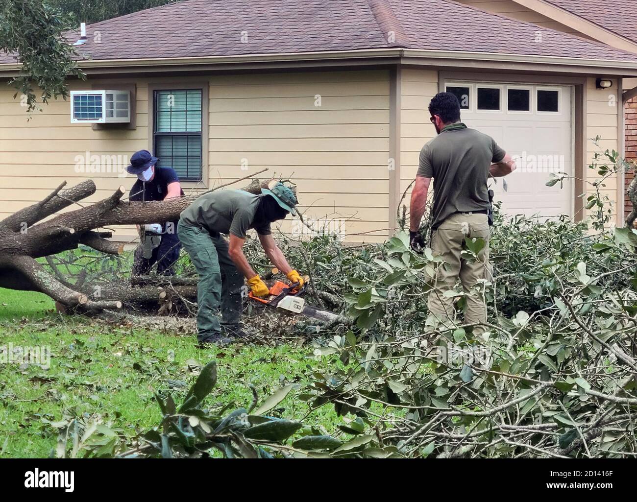Il 26 agosto 2020, agenti del CBP e agenti della pattuglia di confine degli Stati Uniti hanno assistito a sgomberare un albero abbattuto vicino a una casa a Orange, Texas, che era stato danneggiato dall'uragano Laura. Foto Stock
