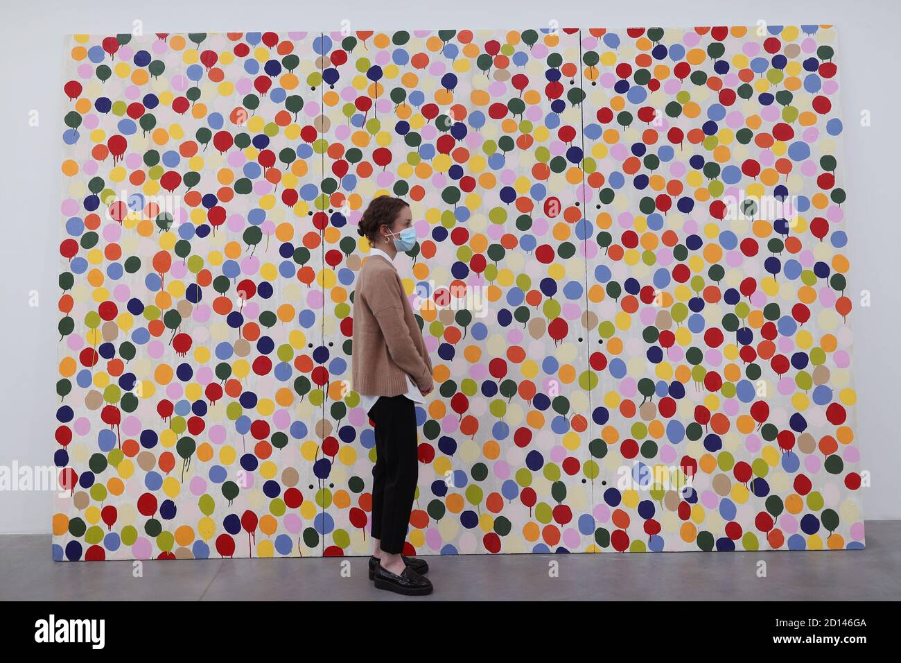 Un membro del personale della galleria si pone accanto a 'Stot Painting', 1986, durante un'anteprima della mostra personale di Damien Hirst intitolata 'fine di un secolo' alla Newport Street Gallery di Londra, Che sarà caratterizzato da oltre cinquanta opere d'arte che dureranno gli anni formativi di Hirst come studente negli anni '80 fino a diventare uno dei principali artisti contemporanei britannici durante gli anni '90. Foto Stock