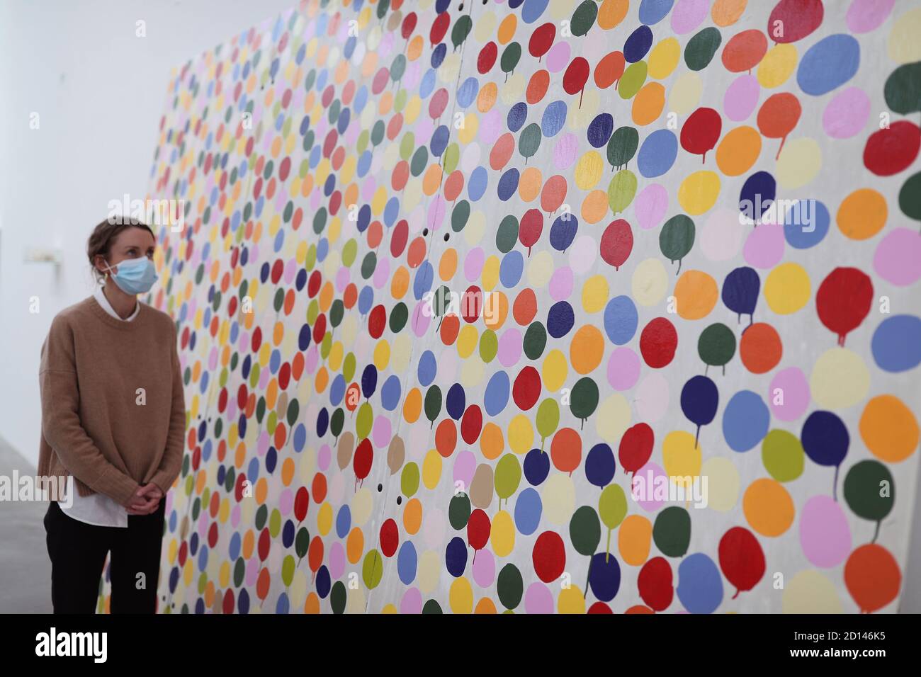 Un membro del personale della galleria si pone accanto a 'Stot Painting', 1986, durante un'anteprima della mostra personale di Damien Hirst intitolata 'fine di un secolo' alla Newport Street Gallery di Londra, Che sarà caratterizzato da oltre cinquanta opere d'arte che dureranno gli anni formativi di Hirst come studente negli anni '80 fino a diventare uno dei principali artisti contemporanei britannici durante gli anni '90. Foto Stock