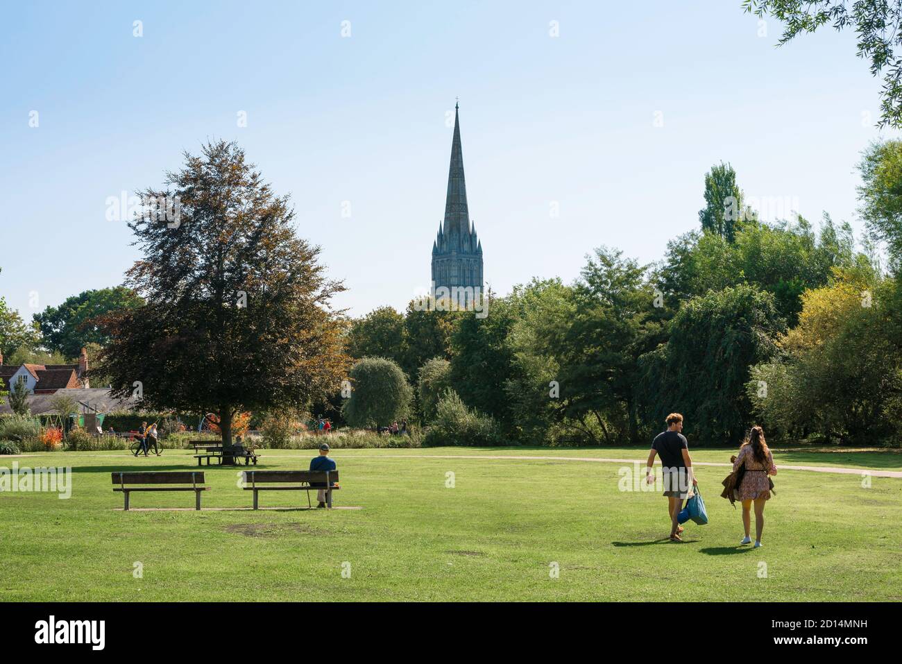 Inghilterra tradizionale, vista in estate di una giovane coppia a piedi attraverso Churchill Gardens Park a Salisbury, Wiltshire, Inghilterra, Regno Unito Foto Stock