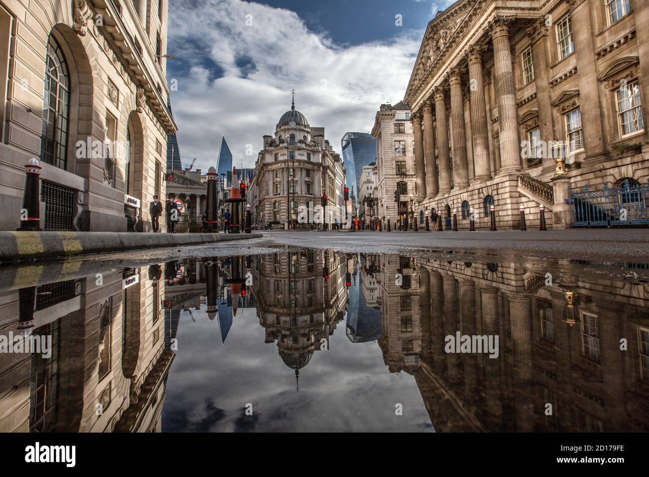 Bank of England e area di Royal Exchange nel cuore del quartiere finanziario della città di Londra si riflettono in un pozze su Threadneedle Street, Londra. Foto Stock