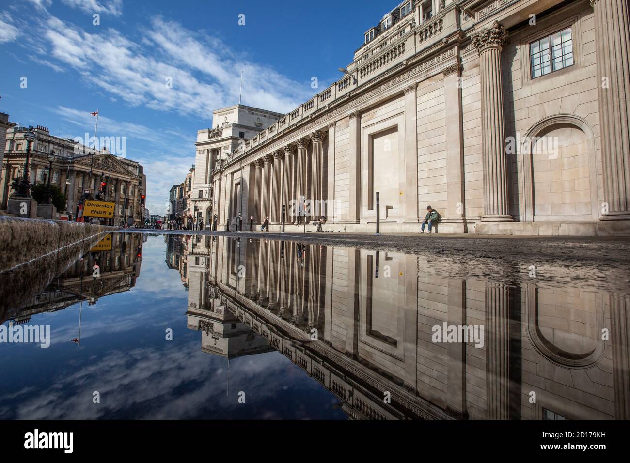 Bank of England e area di Royal Exchange nel cuore del quartiere finanziario della città di Londra si riflettono in un pozze su Threadneedle Street, Londra. Foto Stock