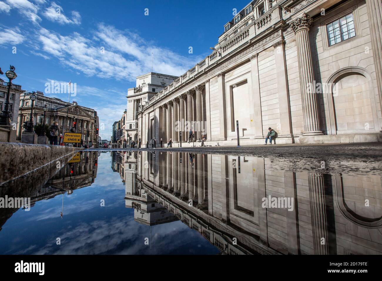Bank of England e area di Royal Exchange nel cuore del quartiere finanziario della città di Londra si riflettono in un pozze su Threadneedle Street, Londra. Foto Stock