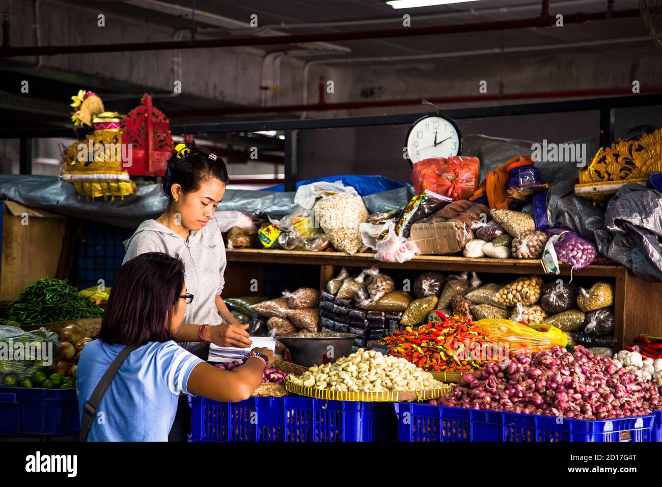 Denpasar, Bali, Indonesia - 8 AGOSTO 2019 : donna che vende frutta e spezie in un colorato coperto segnato Foto Stock