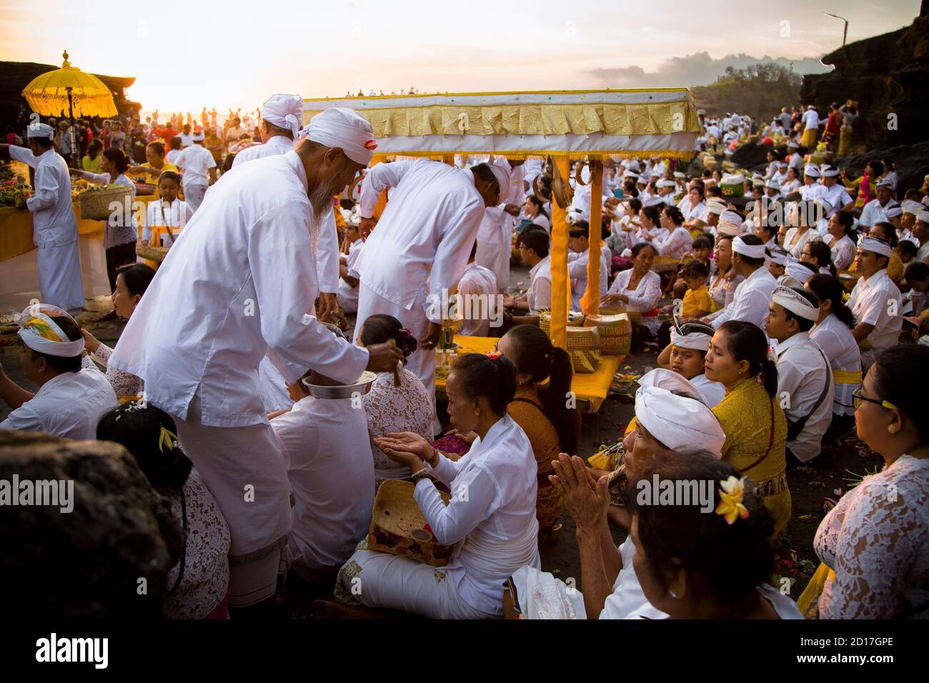 Tanah Lot, Bali, Indonesia - 8 AGOSTO 2019 : donna che riceve la benedizione durante una cerimonia religiosa indù vicino al tempio Foto Stock