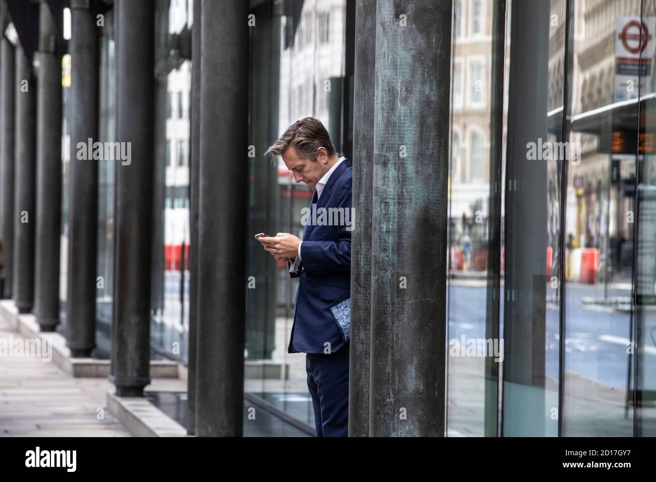 Un banchiere della città fa una pausa fuori da una filiale tranquilla Di Natwest Bank durante l'autunno incertezza di un secondo Blocco del coronavirus in tutto il Regno Unito Foto Stock