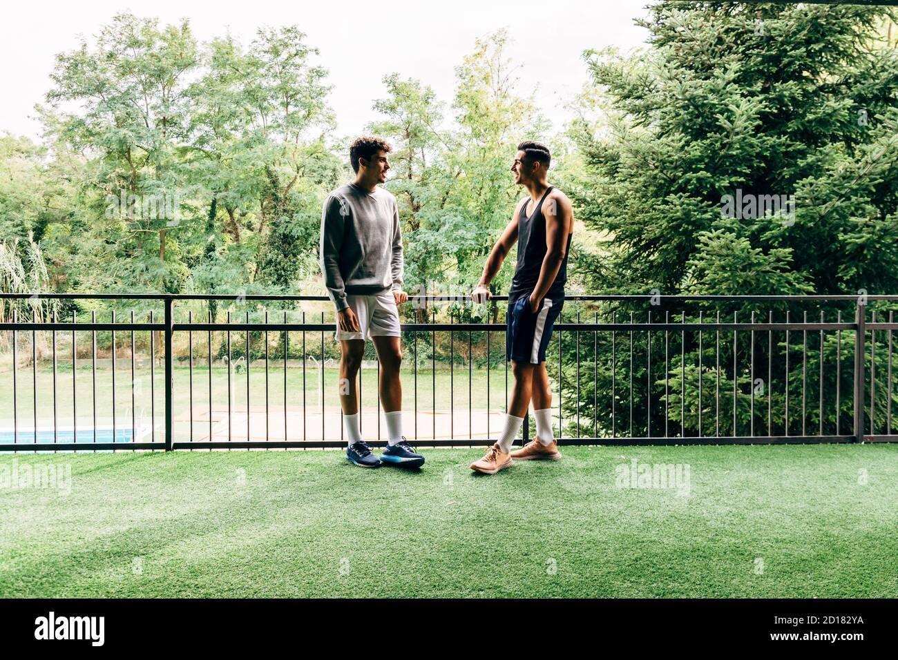 due uomini vestiti di abbigliamento sportivo parlano dopo l'allenamento al palestra Foto Stock