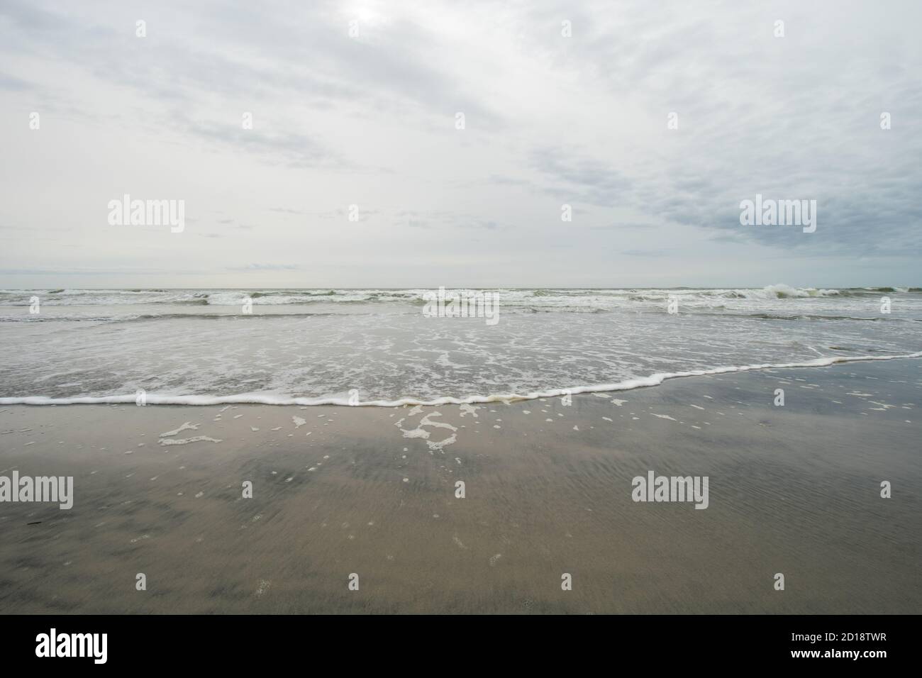 Una vista dell'orizzonte sull'oceano sul Spiaggia su un cielo grigio nuvoloso Foto Stock