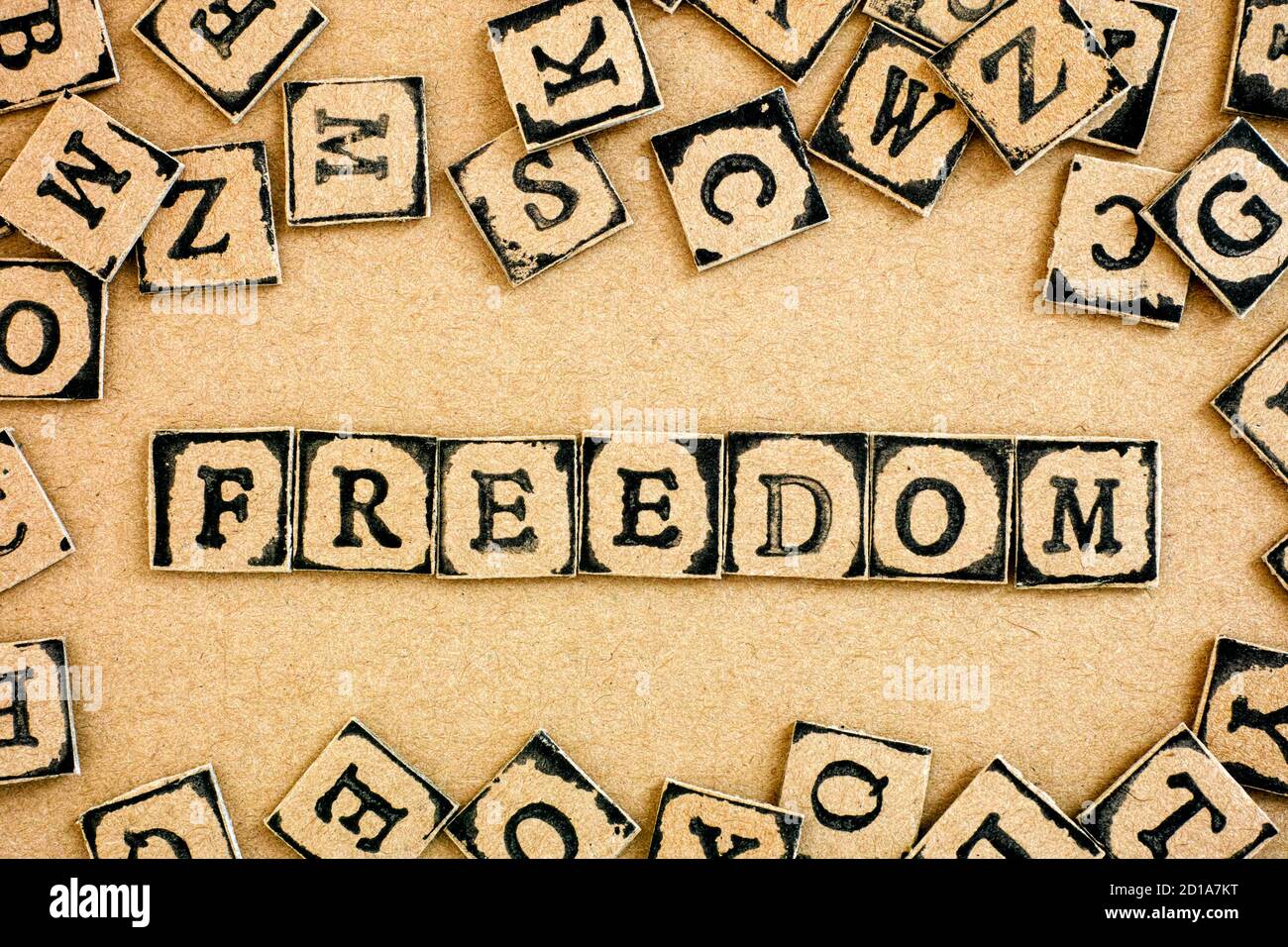 Word Freedom è scritto da lettere di cartone realizzate con francobolli alfabetici neri. Foto Stock