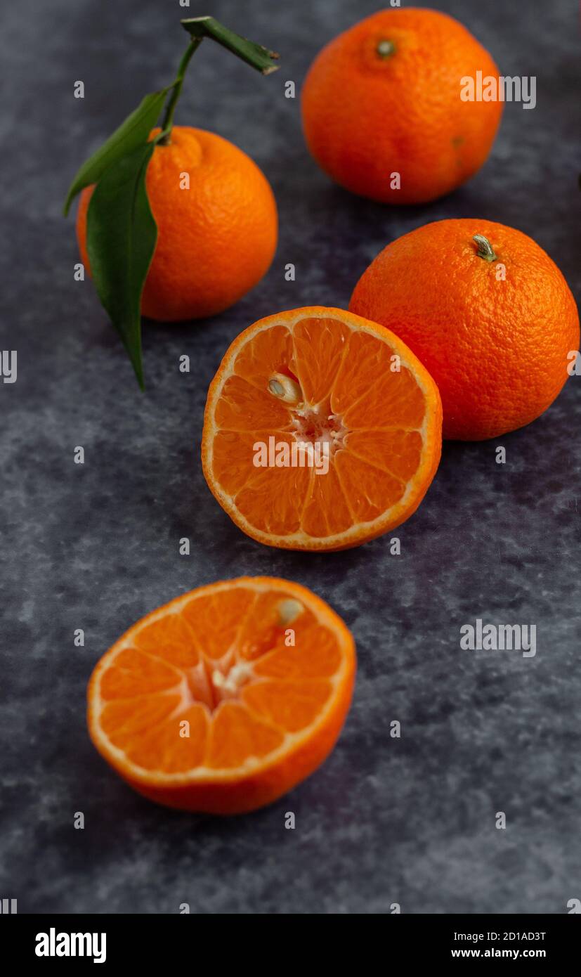 Pezzi interi e mezzo di mandarino su una superficie piana Foto Stock