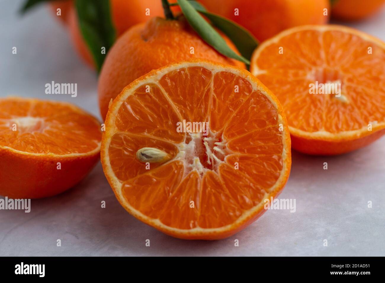 Pezzi interi e mezzo di mandarino su una superficie piana Foto Stock