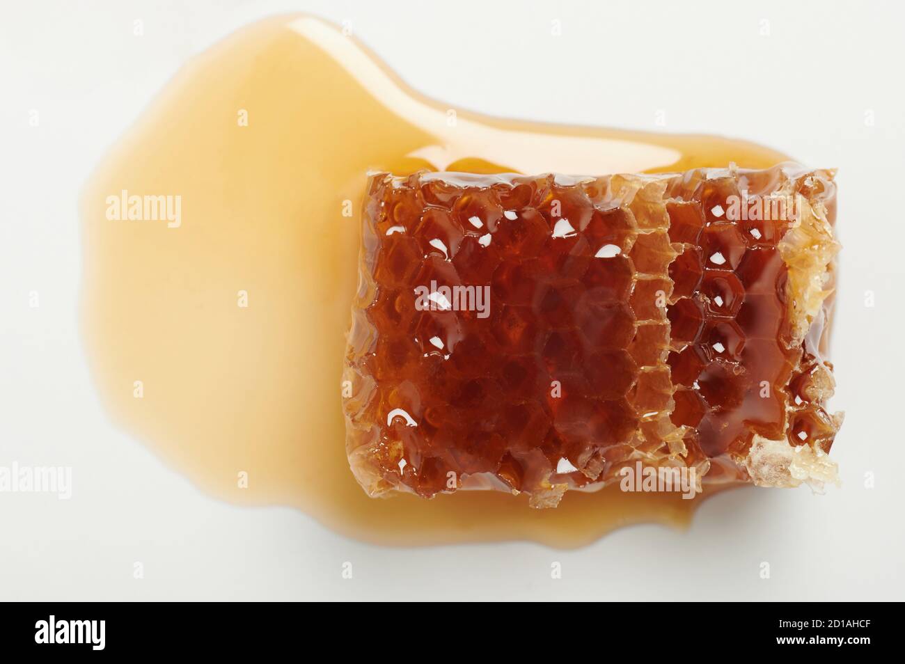 Fetta di miele color oro in pettine con liquido vicino vista verso l'alto Foto Stock