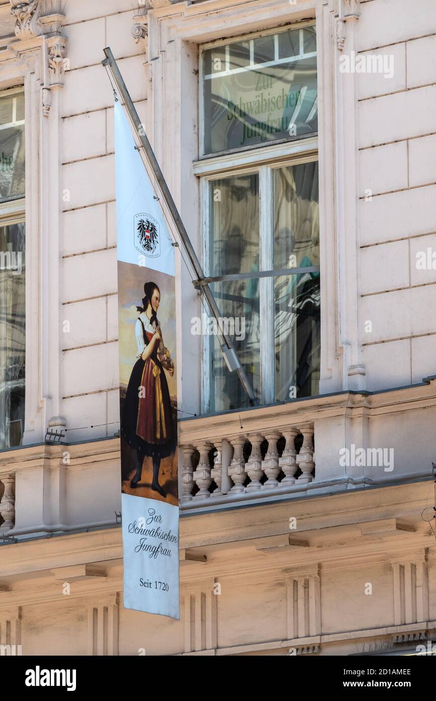 VIENNA, AUSTRIA - 14 LUGLIO 2019: Cartello con la bandiera fuori dal negozio di lino Zur Schwäbischen Jungfrau a Graben Foto Stock