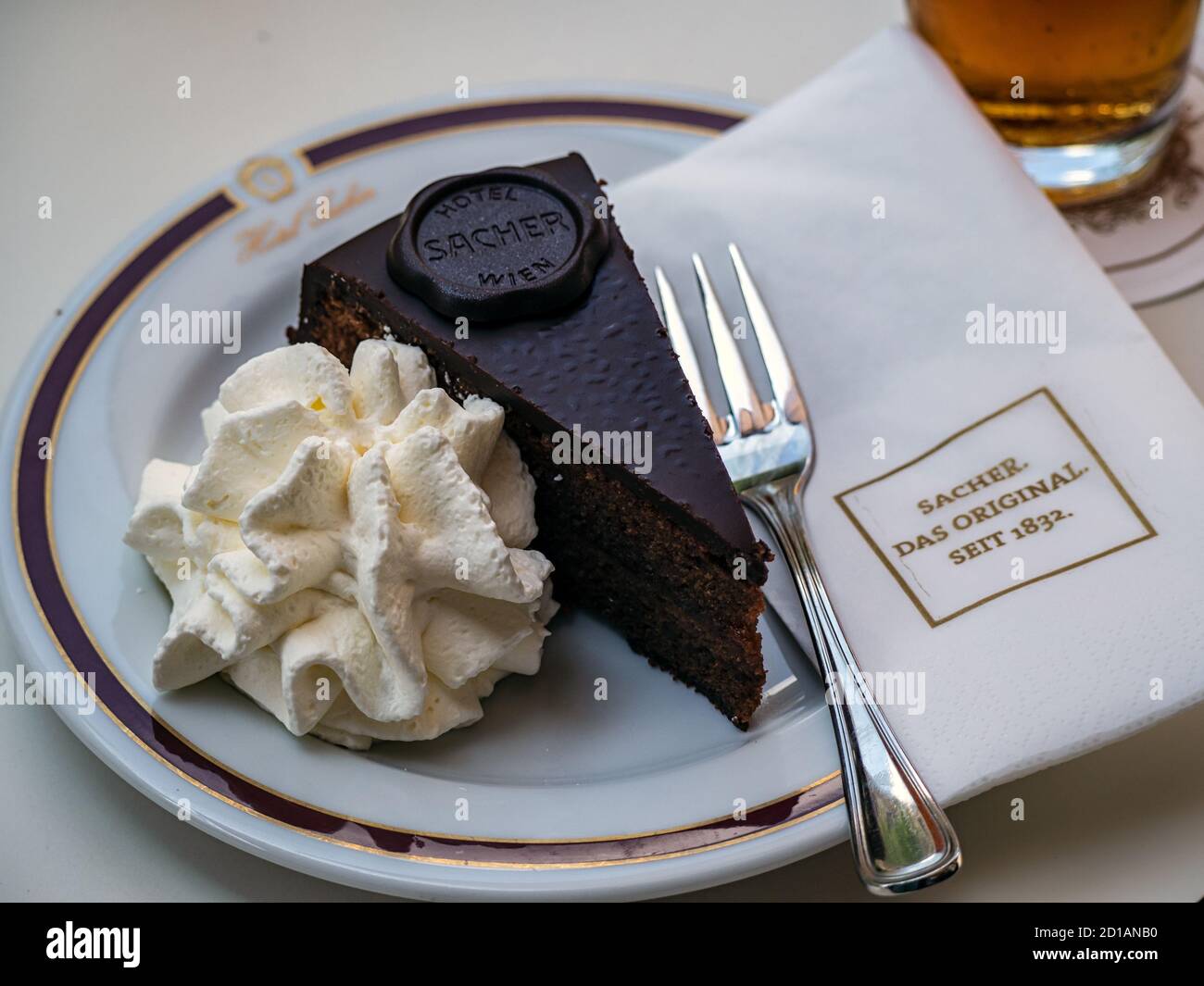 VIENNA, AUSTRIA - 14 LUGLIO 2019: Fetta di torta Sacher sul piatto al Cafe Sacher con tovagliolo di marca Foto Stock
