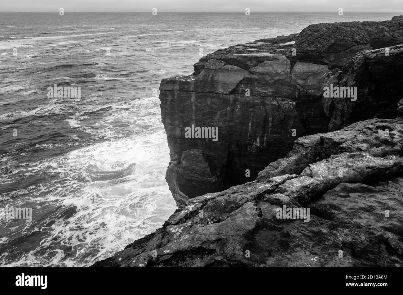 Mare bianco e nero di scogliere irlandesi martoriate dalle onde, Irlanda Foto Stock