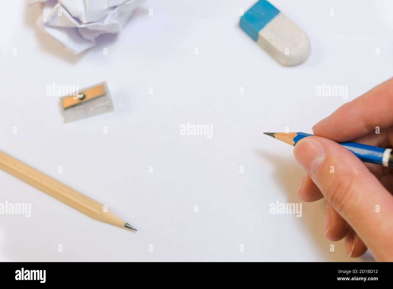 Vista dall'alto della scrittura a mano con matita di legno su carta bianca utilizzando accessori di scrittura. Business, concetto di istruzione. Foto Stock