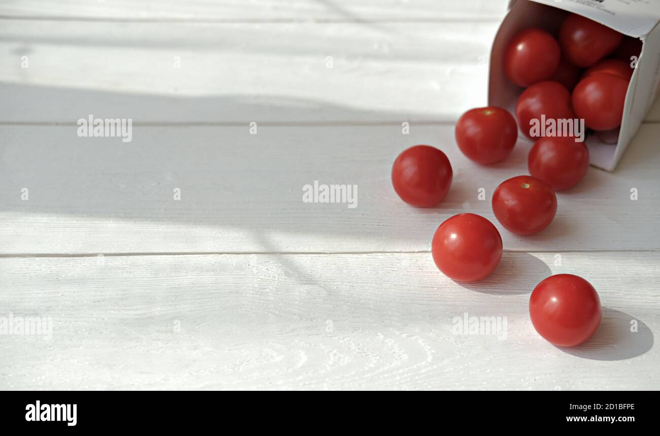 pomodori ciliegini che si diffondono sul tavolo. ingredienti freschi per insalata. vitaminici primaverili ed estive. pasti a bassa dieta di carb. foo per bambini per mangiatori di paky. Foto Stock