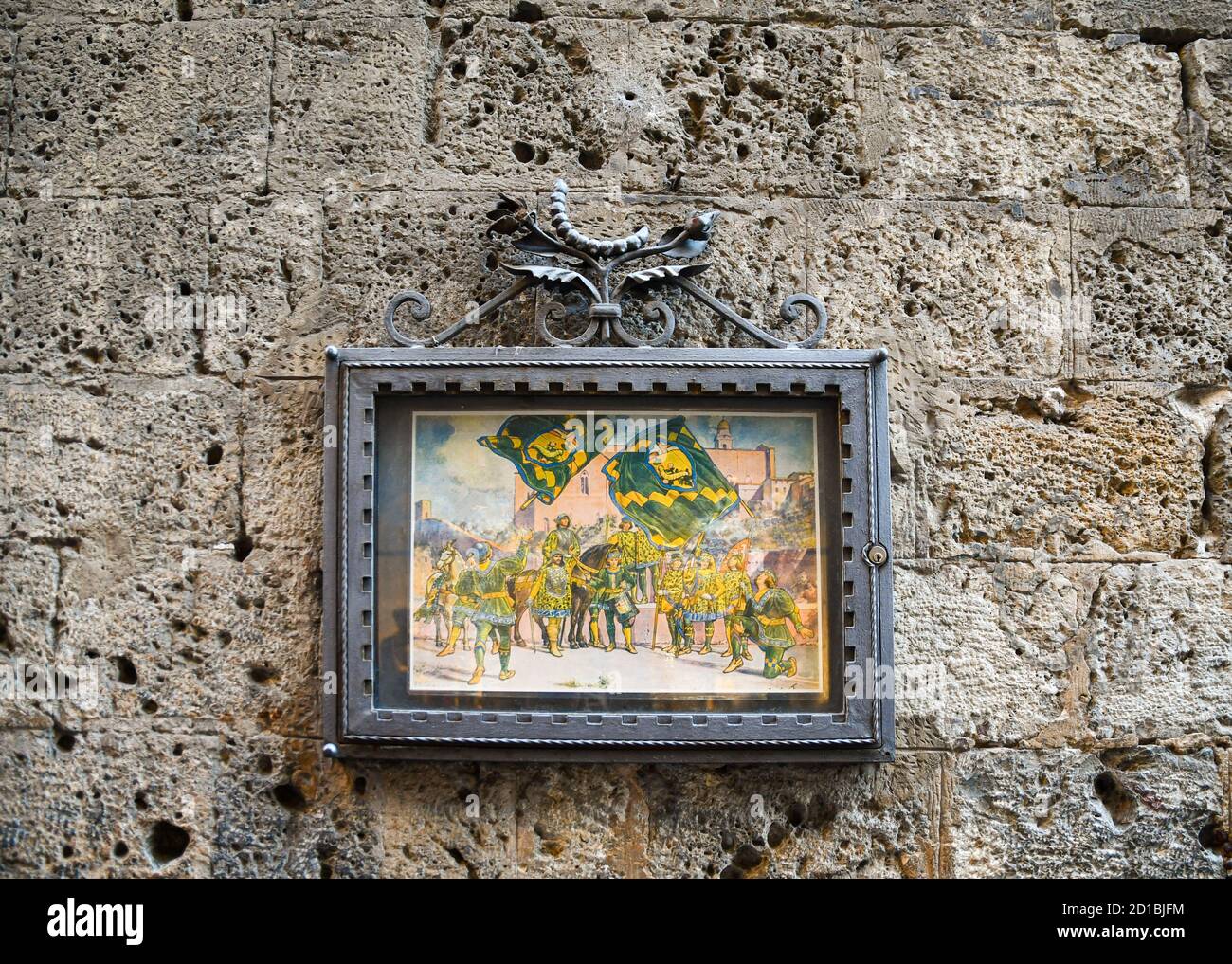 Cornice metallica con i simboli della Nobile Contrada del Bruco, una delle 17 suddivisioni storiche di Siena, su un antico muro di pietra, Toscana, Italia Foto Stock