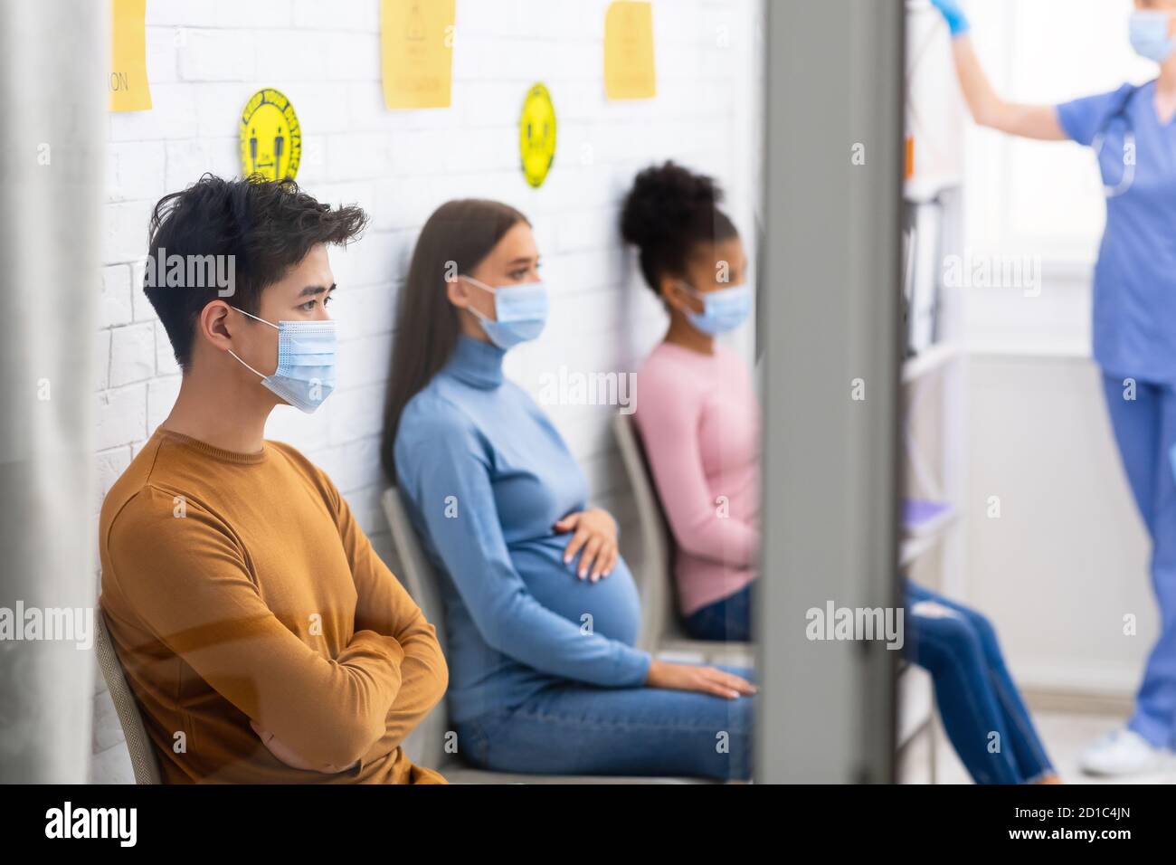 Persone multietniche che si trovano in ospedale in attesa della vaccinazione con Coronavirus Foto Stock