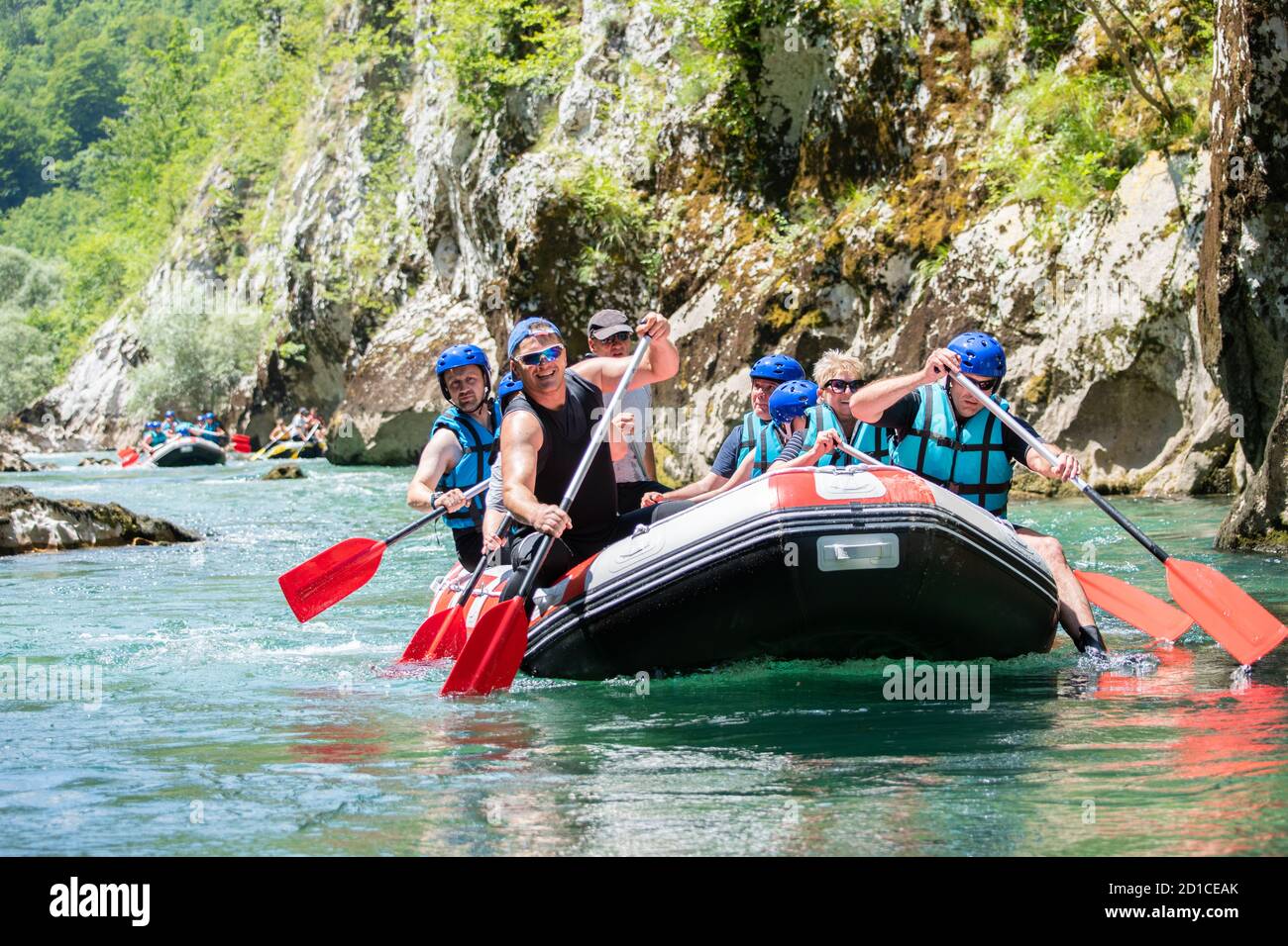 La squadra di rafting scende lungo il fiume nella bella giornata di sole. Foto Stock