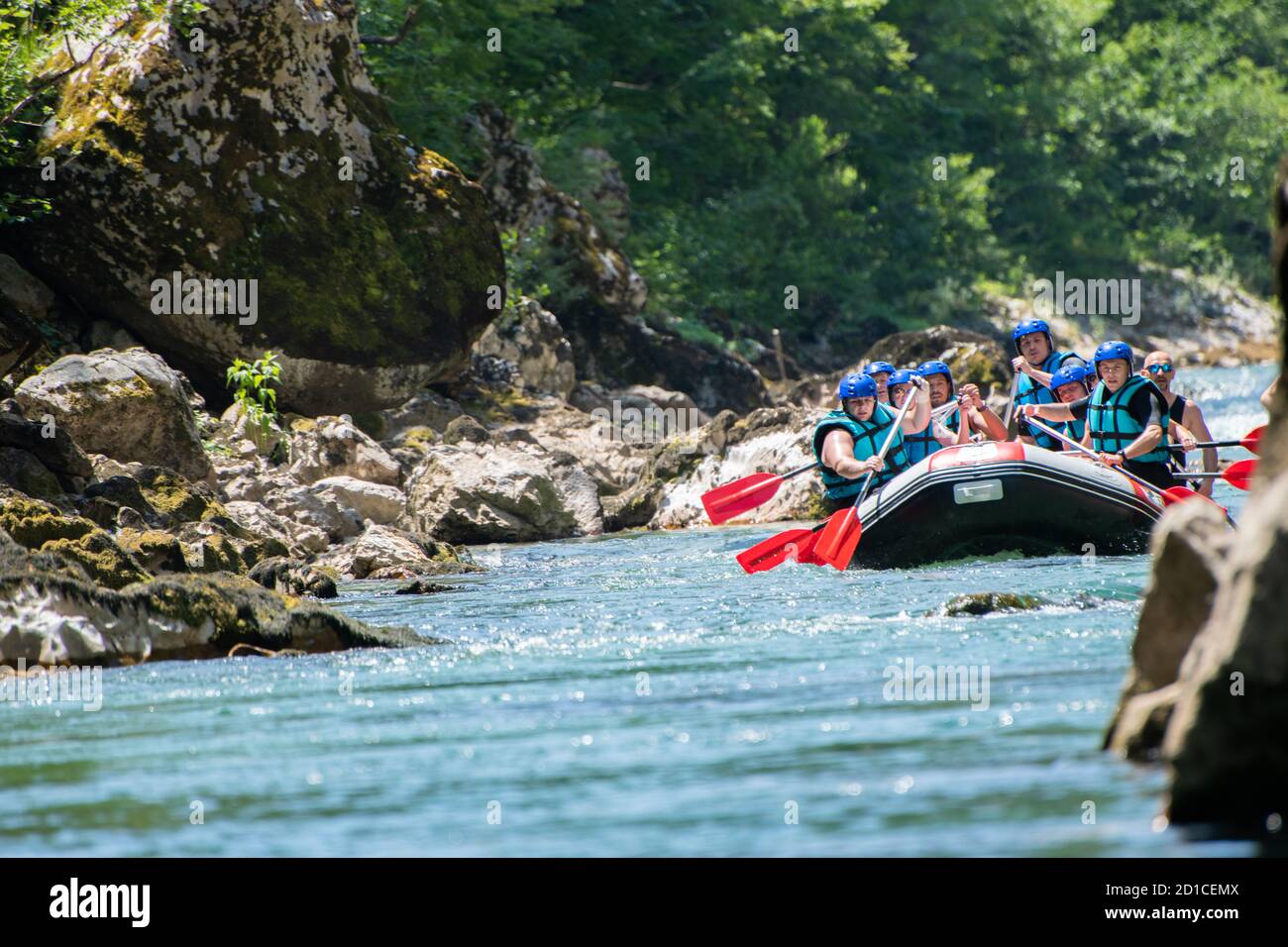 La squadra di rafting scende lungo il fiume nella bella giornata di sole. Foto Stock