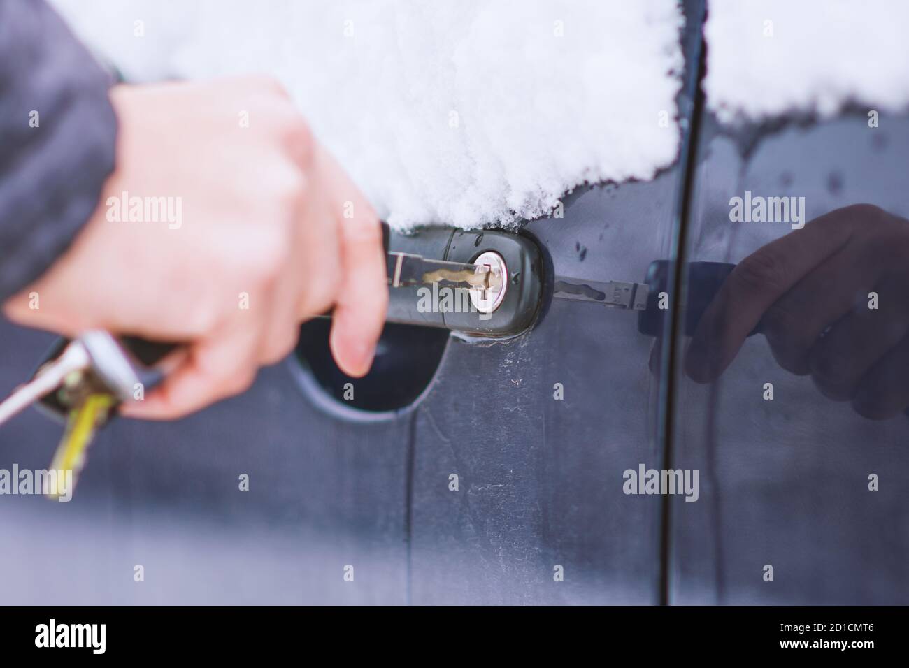 Vista ravvicinata dello sbloccaggio manuale della serratura per auto congelata durante la fredda giornata invernale. Foto Stock