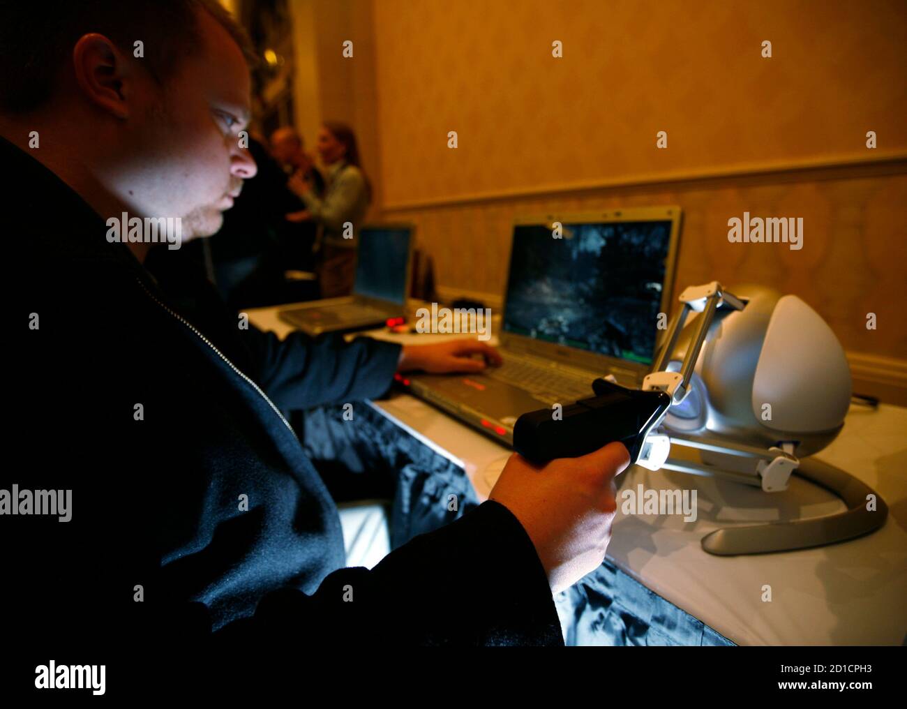 Nathan Kirsch prova il dispositivo touch 3D Novint Technologies Falcon, che ha la forma di una pistola, mentre gioca a "Left 4 Dead" durante l'apertura dell'annuale Consumer Electronics Show a Las Vegas, Nevada, 6 gennaio 2009. REUTERS/Rick Wilking (STATI UNITI) Foto Stock