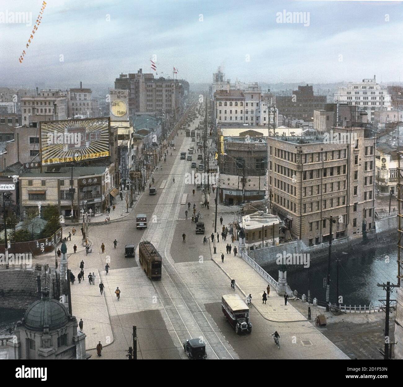 Vista ad alto angolo e colorata del ponte Kyobashi e di Ginza Street, quartiere Ginza, Tokyo, Giappone, 1932. Il grande magazzino Matsuzakya è visibile in alto a sinistra. (Foto di Burton Holmes) Foto Stock