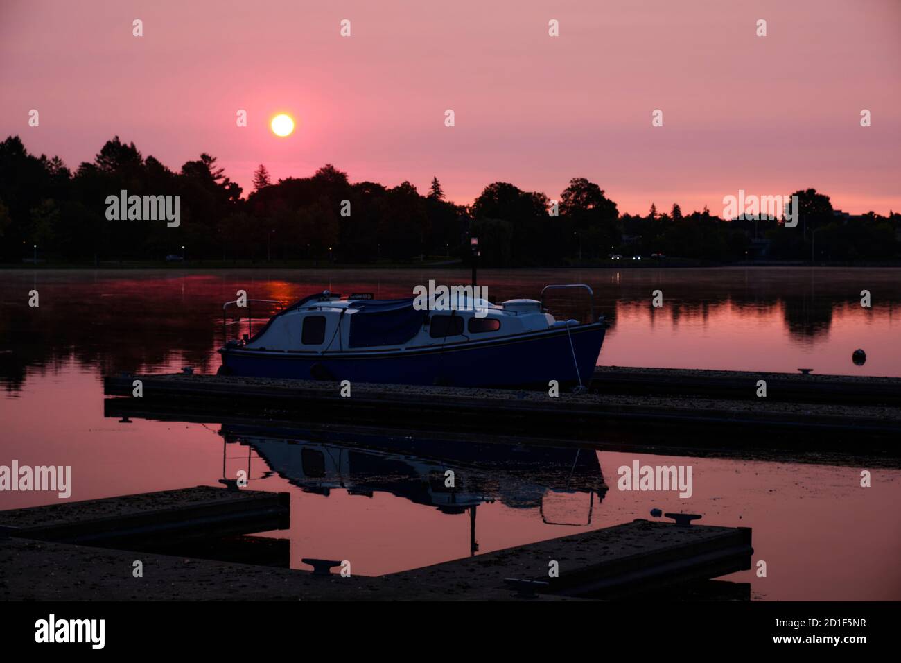 Barca seduto sulle banchine sotto l'alba rosa del mattino presto al Dow's Lake, Ottawa Foto Stock