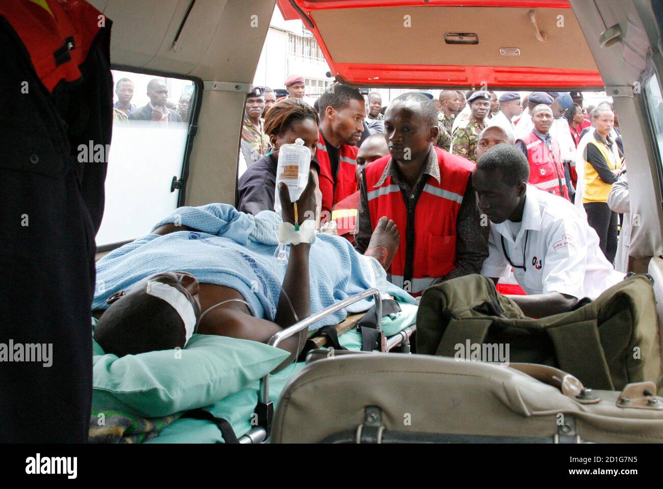 I paramedici all'aeroporto Wilson di Nairobi assistono ad un uomo bruciato dopo che un camion del petrolio si è schiantato ed ha scoppiato nel fuoco vicino alla città della valle del Rift di Molo 1 febbraio 2009. I soccorritori hanno pettinato un sito di incidente in Kenya la domenica, dove circa 100 persone sono state uccise quando il petrolio che stavano scricchiolando per il fuoco catturato in uno dei peggiori incidenti della nazione dell'Africa orientale degli ultimi tempi. REUTERS/Thomas Mukoya (KENYA) Foto Stock